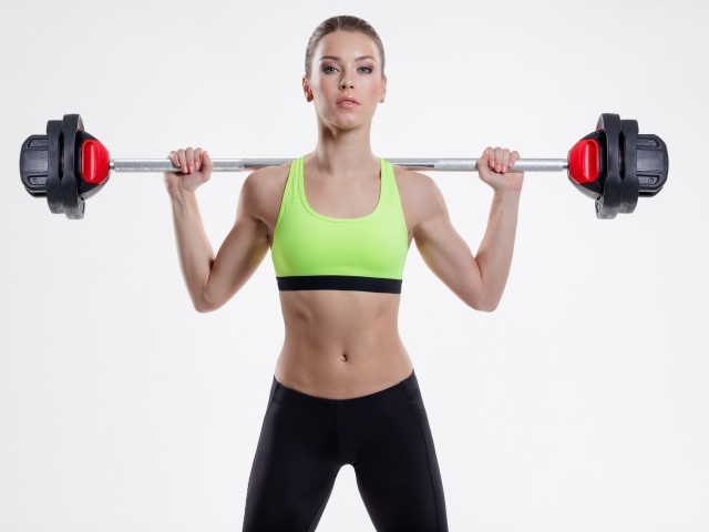 Спортивная девушка со штангой на плечах