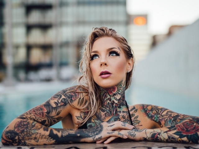 Молодая девушка с красивыми татуировками на теле