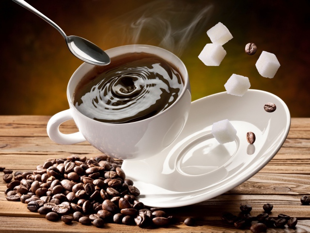 Белая чашка с кофе падает на стол с кофейными зернами