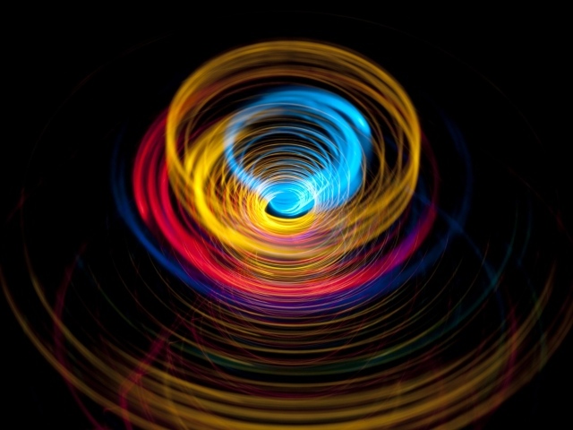 Разноцветные круги в воронке на черном фоне