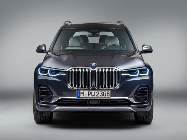 Автомобиль BMW X7  2018 года на сером фоне вид спереди