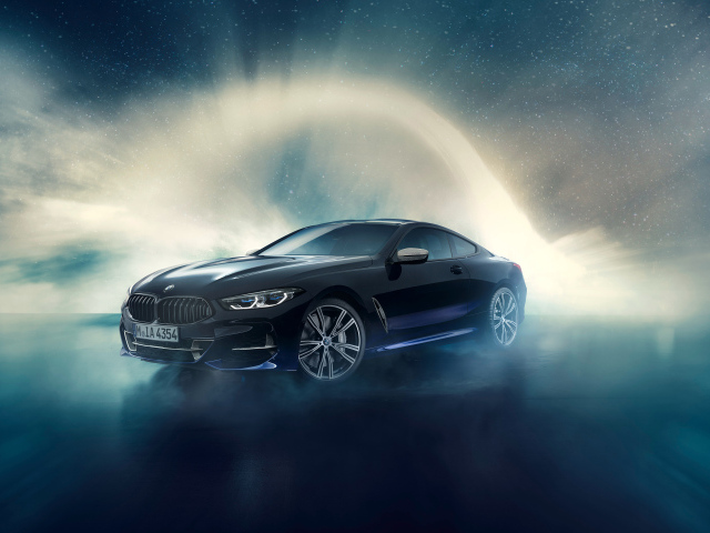 Черный автомобиль BMW M850i, 2019 года на фоне неба