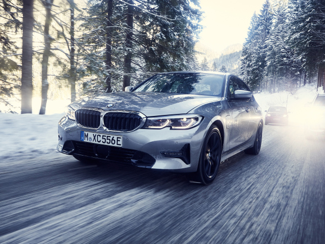 Серый автомобиль BMW 330e 2019 года на скользкой трассе