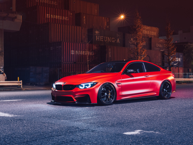 Красный автомобиль BMW M4 на фоне контейнеров