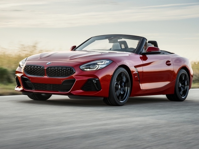 Красный автомобиль кабриолет BMW Z4 на дороге