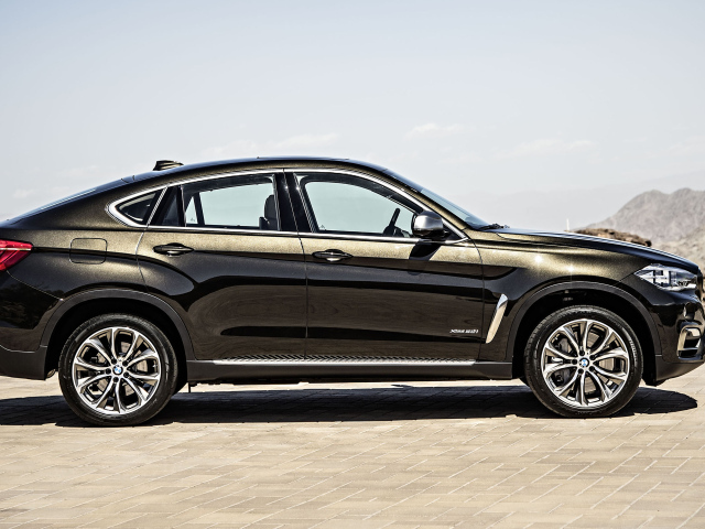 Черный автомобиль BMW X6, 2018 года вид сбоку