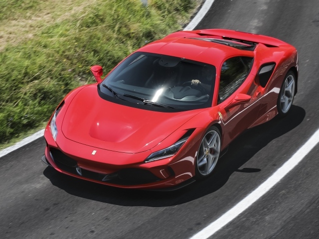 Красный автомобиль Ferrari F8 Tributo 2019 года на дороге