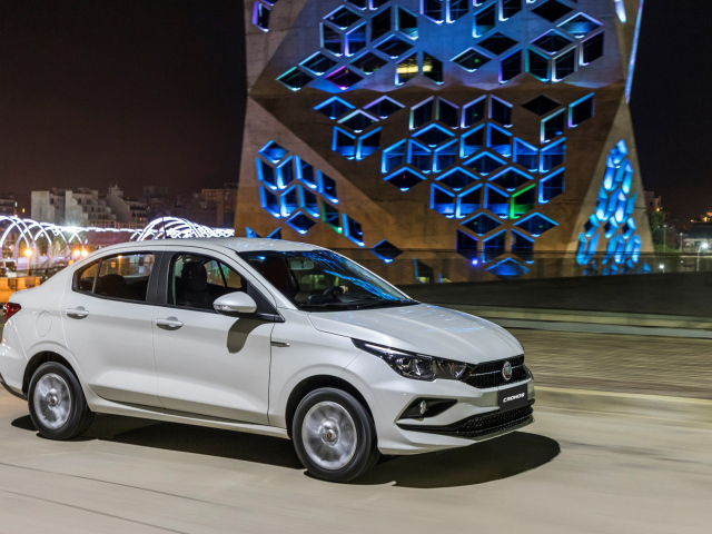 Белый автомобиль Fiat  Cronos, 2018 года на фоне здания