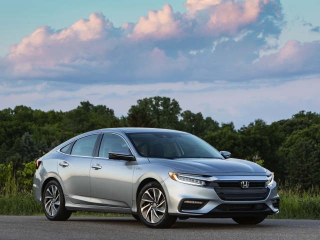 Серебристый автомобиль Honda Insight на фоне леса