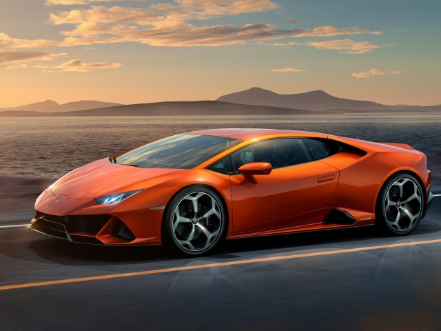 Оранжевый автомобиль Lamborghini Huracan EVO 2019 года на фоне неба 