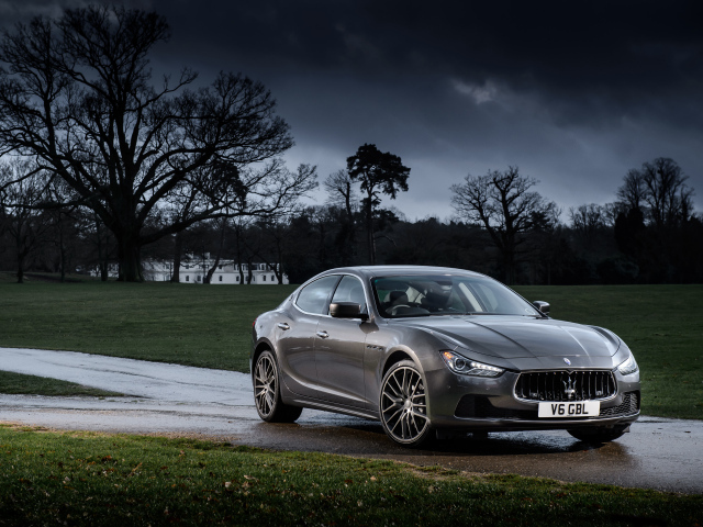 Серебристый автомобиль Maserati Ghibli на фоне грозового неба