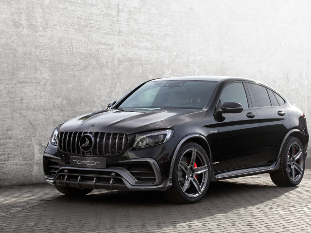 Черный стильный автомобиль Mercedes-AMG GLC-Klasse на фоне серой стены 