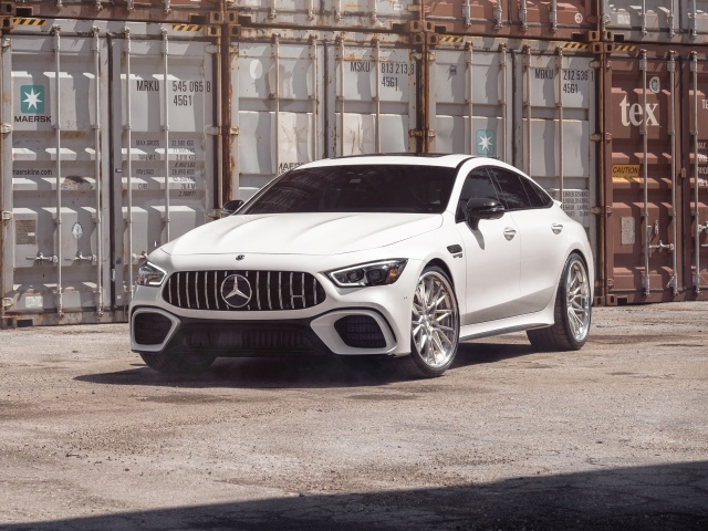 Белый автомобиль Mercedes-AMG GT 63 S стоит у контейнеров