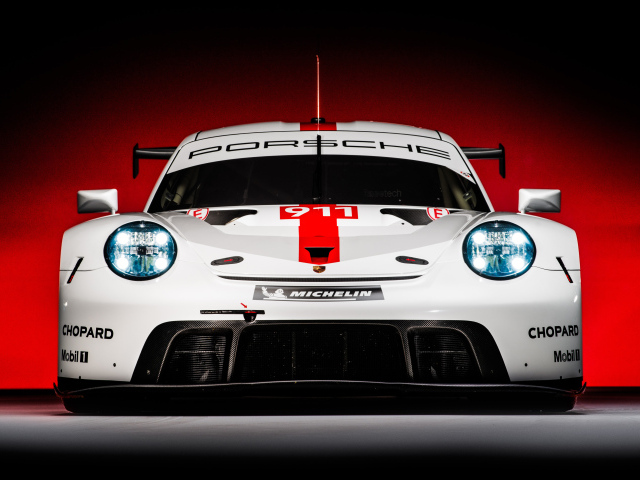 Спортивный автомобиль Porsche 911 RSR 2019 года на красном фоне