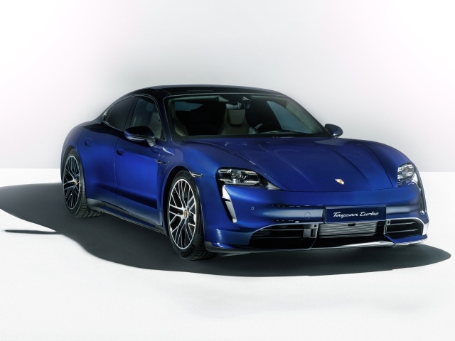 Синий автомобиль Porsche Taycan Turbo 2019 года на сером фоне