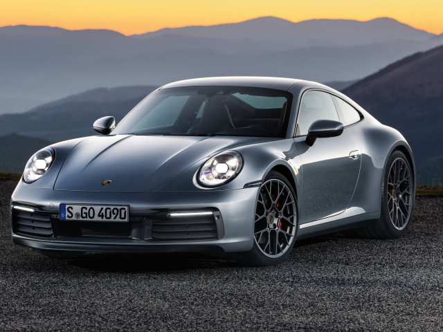 Серебристый автомобиль Porsche 911 Carrera 4S 2019 года на фоне гор 