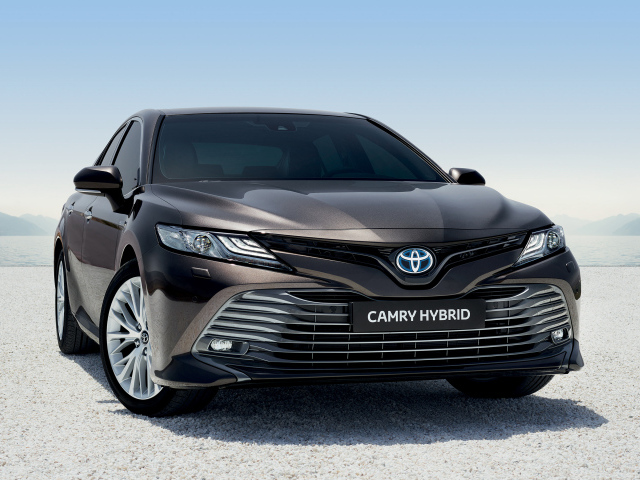 Автомобиль Toyota Camry Hybrid 2019 года стоит на песке