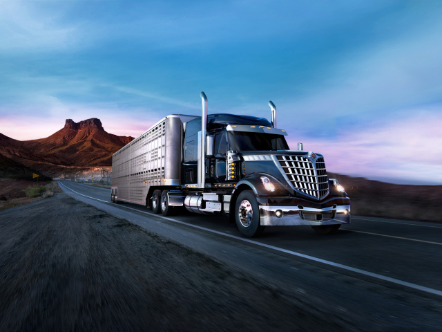 Грузовик International Lone Star на трассе на фоне гор
