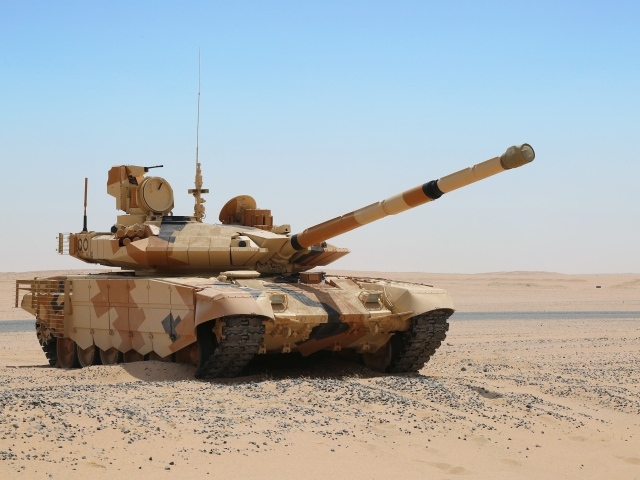 Танк T-90 в пустыне на фоне голубого неба