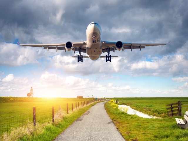 Пассажирский самолет взлетает над полем 