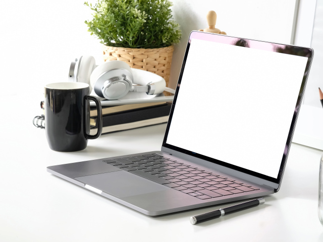 Ноутбук на рабочем столе с чашкой 