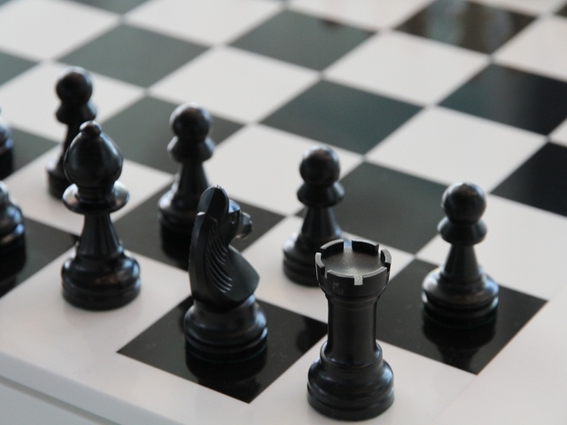 Черные шахматные фигуры на доске