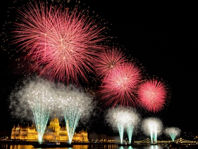 Взрывы яркого салюта над ночным городом 