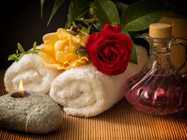 Розы, банные полотенца, свеча и ароматное масло 