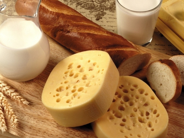 Сыр на столе с маслом, молоком и батоном 