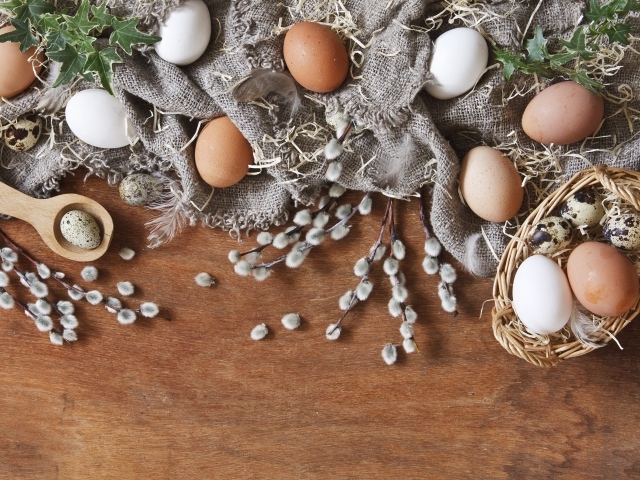 Куриные и перепелиные яйца на столе в ветками вербы