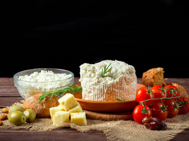 Творог на столе с сыром, хлебом и помидорами