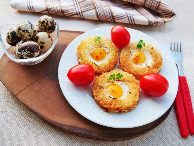 Гренки с яичницей и помидорами на столе с перепелиными яйцами 