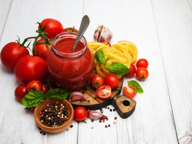 Кетчуп на столе с помидорами, специями и пастой