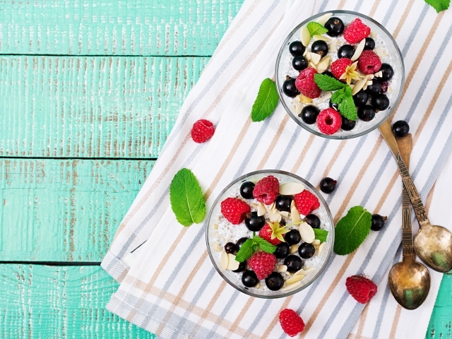 Легкий завтрак с мюсли и ягодами на столе с ложками