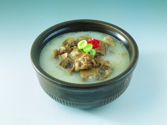 Тарелка супа с говядиной  на голубом фоне