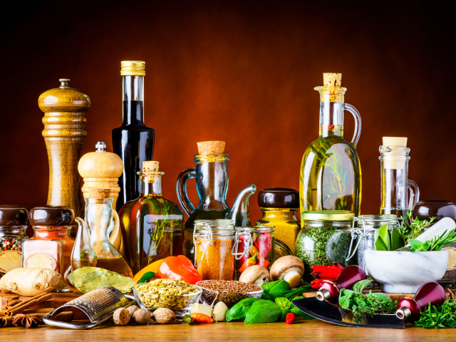 Специи, зелень и масла на столе 