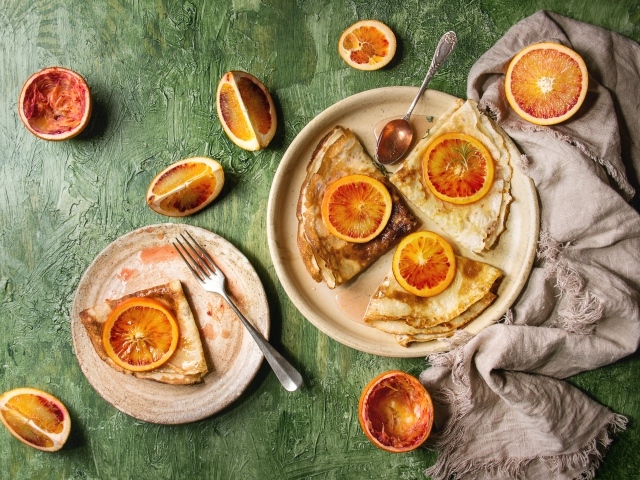 Тонкие блинчики с апельсинами на столе