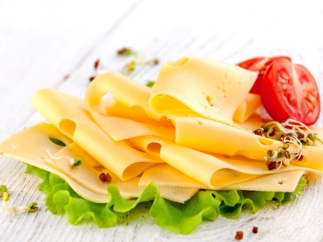 Тонко нарезанный сыр с листом салата и помидором