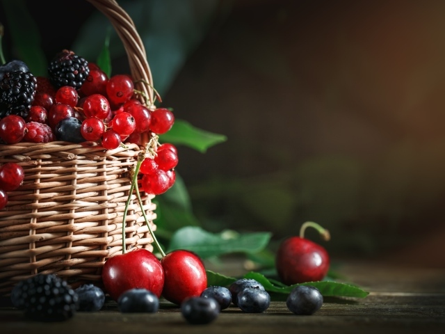 Корзина с ягодами черники, малины, красной смородины и черешни