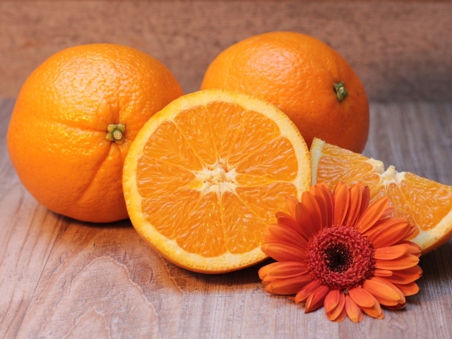 Спелые сочные апельсины с цветком герберы