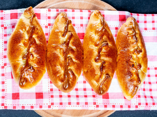 Аппетитные румяные пирожки лежат на полотенце 