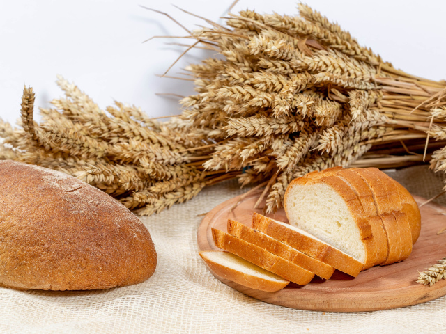 Свежий ароматный хлеб на столе с колосьями пшеницы