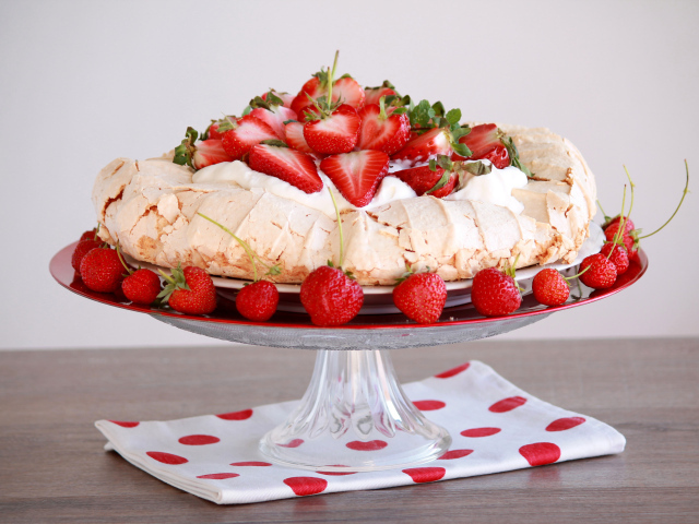 Аппетитный десерт Павлова на блюде с клубникой