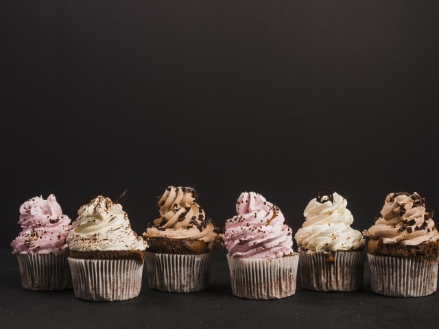 Аппетитные кексы с кремом на сером фоне