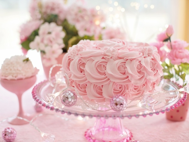 Красивый розовый торт на столе с цветами