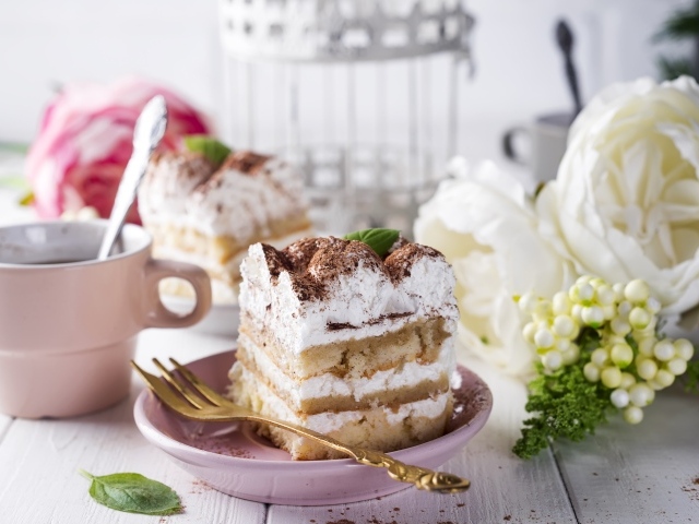 Пирожное на столе с кофе и цветами 