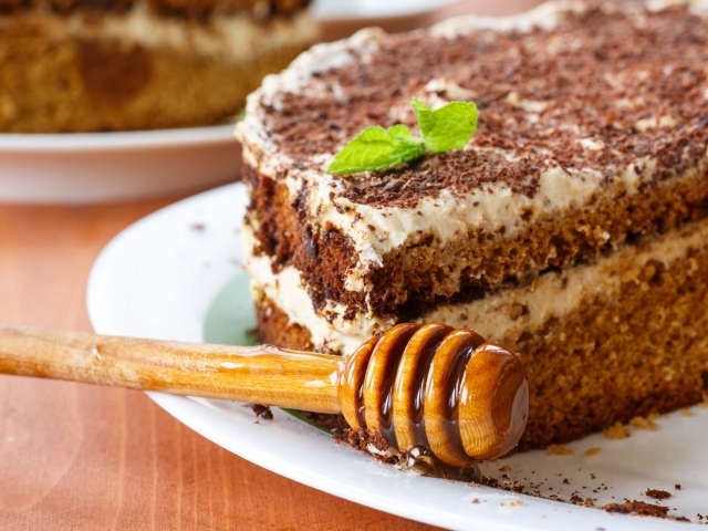 Торт с кремом и шоколадом на тарелке с ложкой для меда