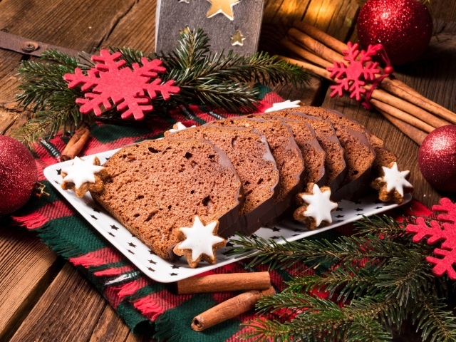 Рождественский кекс на столе с еловыми ветками и корицей