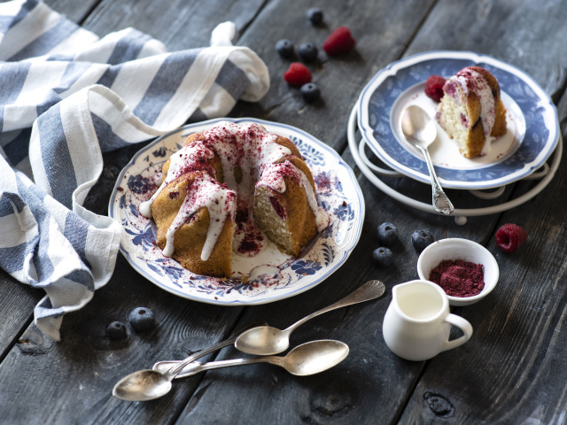 Кекс с кремом и ягодами на столе 