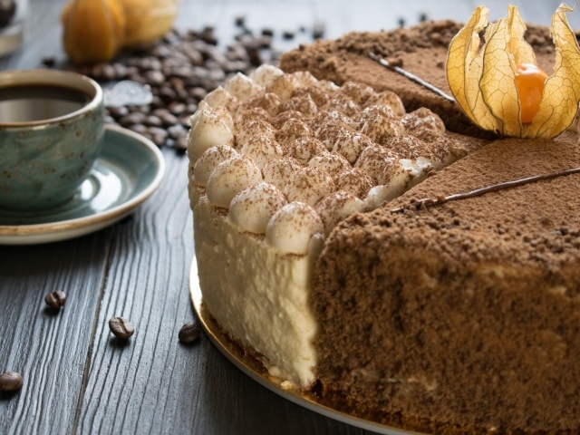 Вкусный торт с кремом и физалисом на столе с кофе